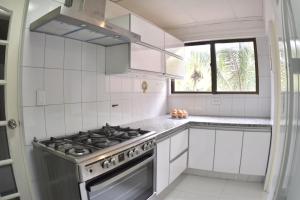 a white kitchen with a stove and a window at Oasis Urbano in Santa Cruz de la Sierra