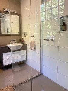 a bathroom with a glass shower and a sink at Forth River Cottage in Forth