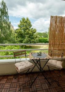 d'une terrasse avec une table et deux chaises sur un balcon. dans l'établissement LES DUNES Studio Cosy-Terrasse-Parking -Proche paris, à Vitry-sur-Seine