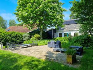 a patio with benches and a house in the background at Vakantiehuis Oostkapelle OK41 in Oostkapelle