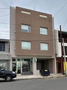 a car parked in front of a brown building at Estepa Apart 1B calidad y confort in Comodoro Rivadavia