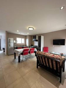 uma sala de estar com cadeiras vermelhas e uma cozinha em Estepa Apart 1B calidad y confort em Comodoro Rivadavia