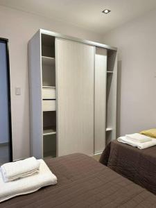 sypialnia z 2 łóżkami i szafą w obiekcie Estepa Apart 1B calidad y confort w mieście Comodoro Rivadavia