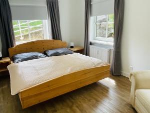 フェルデン・アム・ヴェルターゼーにあるVelden Pool Appartementの窓2つ付きのドミトリールームの木製ベッド1台分です。