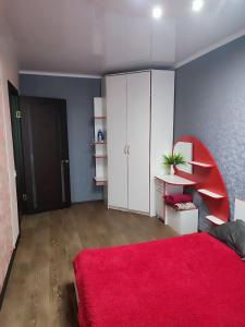 a living room with a red rug and a red bed at Апартаменты 2-х комнатные в Степногорске in Stepnogorsk