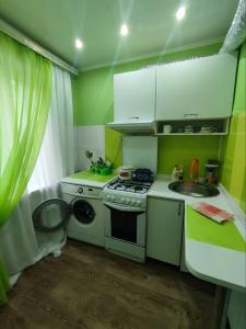 una pequeña cocina con fogones y fregadero en Апартаменты 2-х комнатные в Степногорске en Stepnogorsk