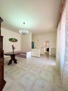- un salon avec une table et un lustre dans l'établissement La Maison De Rose, à Torre Annunziata