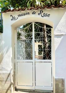 an entrance to a white door with a gate at La Maison De Rose in Torre Annunziata