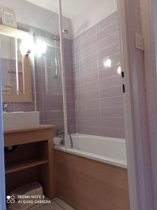 a bathroom with a tub and a sink and a mirror at Chez Alex & Max - Appartement duplex entre forêt et océan in Moliets-et-Maa