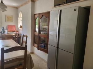 a kitchen with a refrigerator and a table in a room at Villa gitedelea in Aubignan