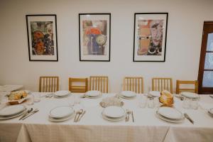 mesa de comedor con platos y utensilios blancos en Pensiunea Nobila, en Beclean