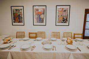 a dining room table with white plates and utensils at Pensiunea Nobila in Beclean