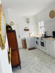 a kitchen with white cabinets and a washing machine at Dar zmen 