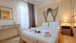 a bedroom with a bed with towels and a mirror at Lourantos Studios & Apartments in Vathi