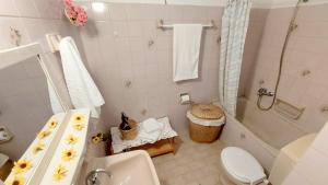 a bathroom with a tub and a toilet and a sink at Lourantos Studios & Apartments in Vathi +56 photos