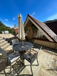 a patio table with an umbrella and two chairs at 2 Westview in St. Brelade