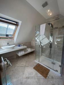 y baño con ducha y lavamanos. en 2 Westview en St Brelade