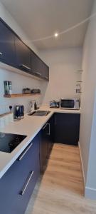 a kitchen with black and white cabinets and wooden floors at The Nest in Coveney