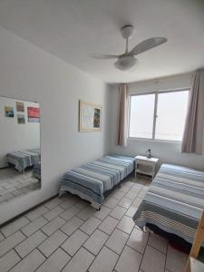 Zimmer mit 2 Betten und einem Fenster in der Unterkunft Quarto em apartamento da Sandra in Balneário Camboriú