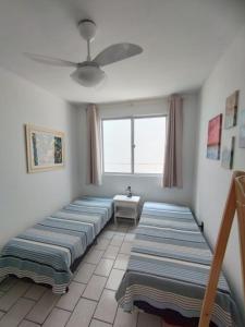 4 Betten in einem Zimmer mit Fenster in der Unterkunft Quarto em apartamento da Sandra in Balneário Camboriú