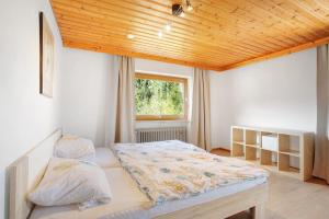 - une chambre avec un lit et un plafond en bois dans l'établissement Wohnung Hochstaufen, à Inzell