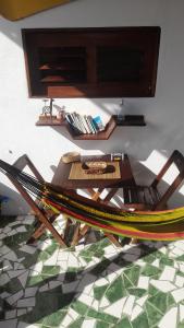 a table and a chair with a table and a floor at Hopa Shelter Surf House Apartamento in Paracuru