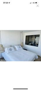 Una cama blanca con dos almohadas encima. en Marina Port Camargue appontement bateau, en Le Grau-du-Roi