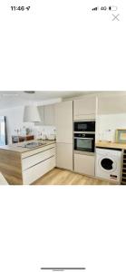 Una cocina con gabinetes blancos y un horno de estufa. en Marina Port Camargue appontement bateau, en Le Grau-du-Roi 5 fotos más