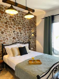 a bedroom with a bed with a stone wall at Althea Apartments in Kolymbia