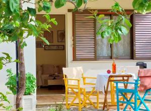 een tafel en stoelen op de veranda van een huis bij Lourantos Studios & Apartments in Vathi