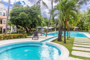 een zwembad in een resort met palmbomen bij Infinity blue family suite in Sosúa