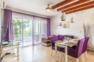 een woonkamer met een eettafel en paarse stoelen bij Infinity blue family suite in Sosúa