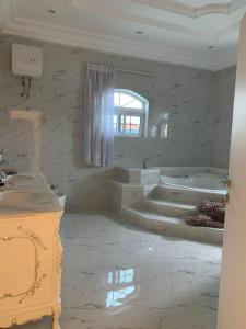 uma casa de banho branca com 2 lavatórios e 2 banheiras em 6 MANSION em Acra