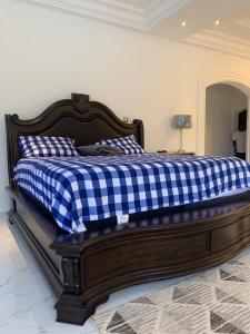 uma cama com um cobertor xadrez azul e branco em 6 MANSION em Acra