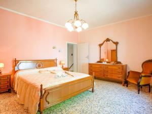 a bedroom with a bed and a dresser and a mirror at Belvilla by OYO La Casa dei Nonni in Chianni
