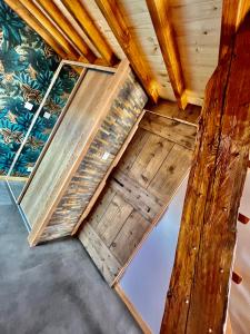 a room with wooden floors and a wall with plants at Le Mélèze in Villar-Saint-Pancrace