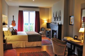 a bedroom with a bed and a desk and a fireplace at Legado Mitico Buenos Aires in Buenos Aires