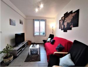 sala de estar con sofá rojo y TV en LE PHARE en Criel-sur-Mer