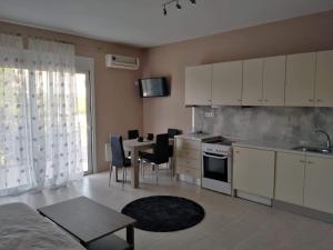 a kitchen with white cabinets and a table and chairs at Brand new spacious studio in Itea