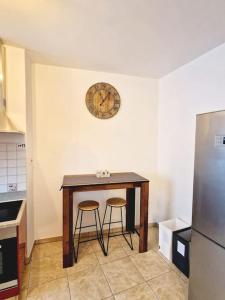 eine Küche mit einem Tisch mit zwei Hockern und einer Uhr an der Wand in der Unterkunft Appartamento 4.5 - Gordola in Gordola