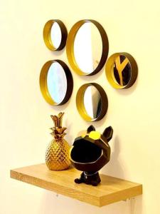 un estante con una piña y espejos en la pared en Appartamento 4.5 - Gordola, en Gordola