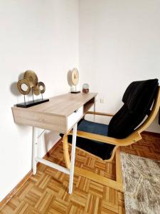 un escritorio con una silla junto a una mesa en Appartamento 4.5 - Gordola, en Gordola