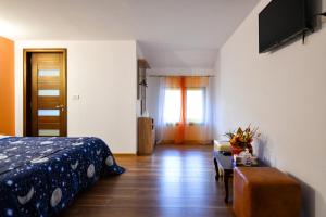 a bedroom with a bed and a table and a tv at Villa CASTELLINO in Târgu Ocna