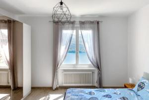 a bedroom with a bed and a window at Casa Ruth Brissago in Brissago
