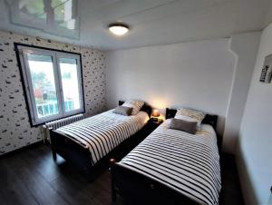 Duas camas num quarto com uma janela em LE PHARE em Criel-sur-Mer