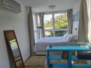 1 dormitorio con cama, ventana y mesa en Nature Oasis near Barcelona with swimming pool, en Sant Cugat del Vallès