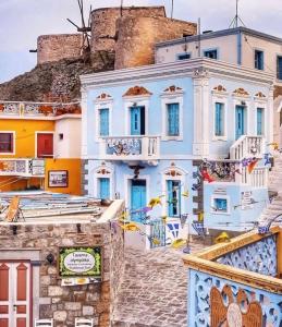 a building in positano with blue doors and stairs at Grannys Luxury Villas in Karpathos