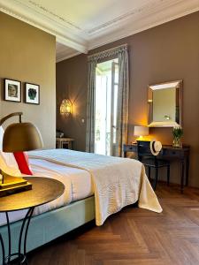 a bedroom with a bed with a table and a mirror at Le Gabriel in Claviers