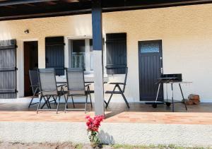 eine Terrasse mit Stühlen und einem Tisch auf einem Haus in der Unterkunft Maison Léon in Ychoux