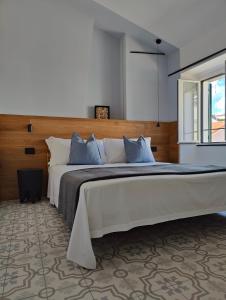 a bedroom with a large bed with blue pillows at Casa Aicardi in Alassio